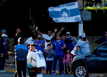 Para pendukung mengibarkan bendera bergambar Maradoa terlihat di luar Stadion sebelum berlangsung pertandingan antara Gimnasia y Esgrima dan Patronato, di Estadio Juan Carlos Zerillo, La Plata, Buenos Aires, Argentina, Jumat (30/10/2020). Tepat pada hari ini tanggal 30 Oktober 2020 legenda sepak bola Argentina itu berusia 60 tahun. ANTARA FOTO/Pool via Reuters-Demian Alday Estevez/hp.