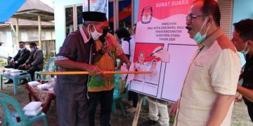 Salah seorang tokoh masyarakat melakukan simulasi Mencoblos Calon Walikota dan Wakil Walikota Pematangsiantar Ir Asner Silalahi MT - dr Susanti Dewayani SpA pada kertas suara untuk Pilkada 9 Desember 2020.(foto.tim)
